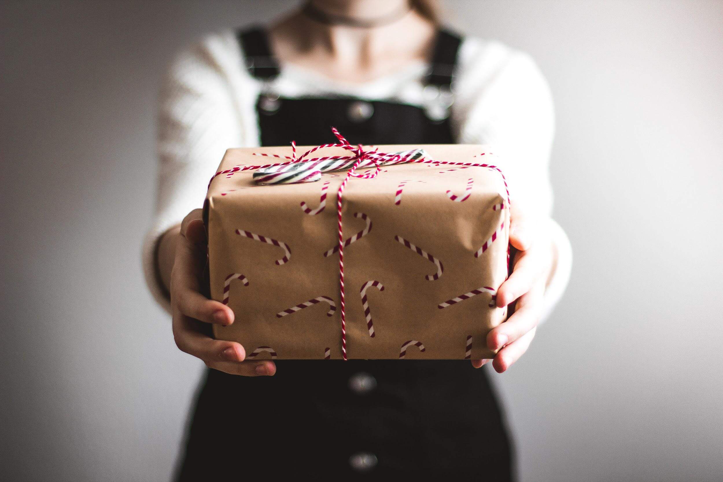 woman holding out wrapped festive gift